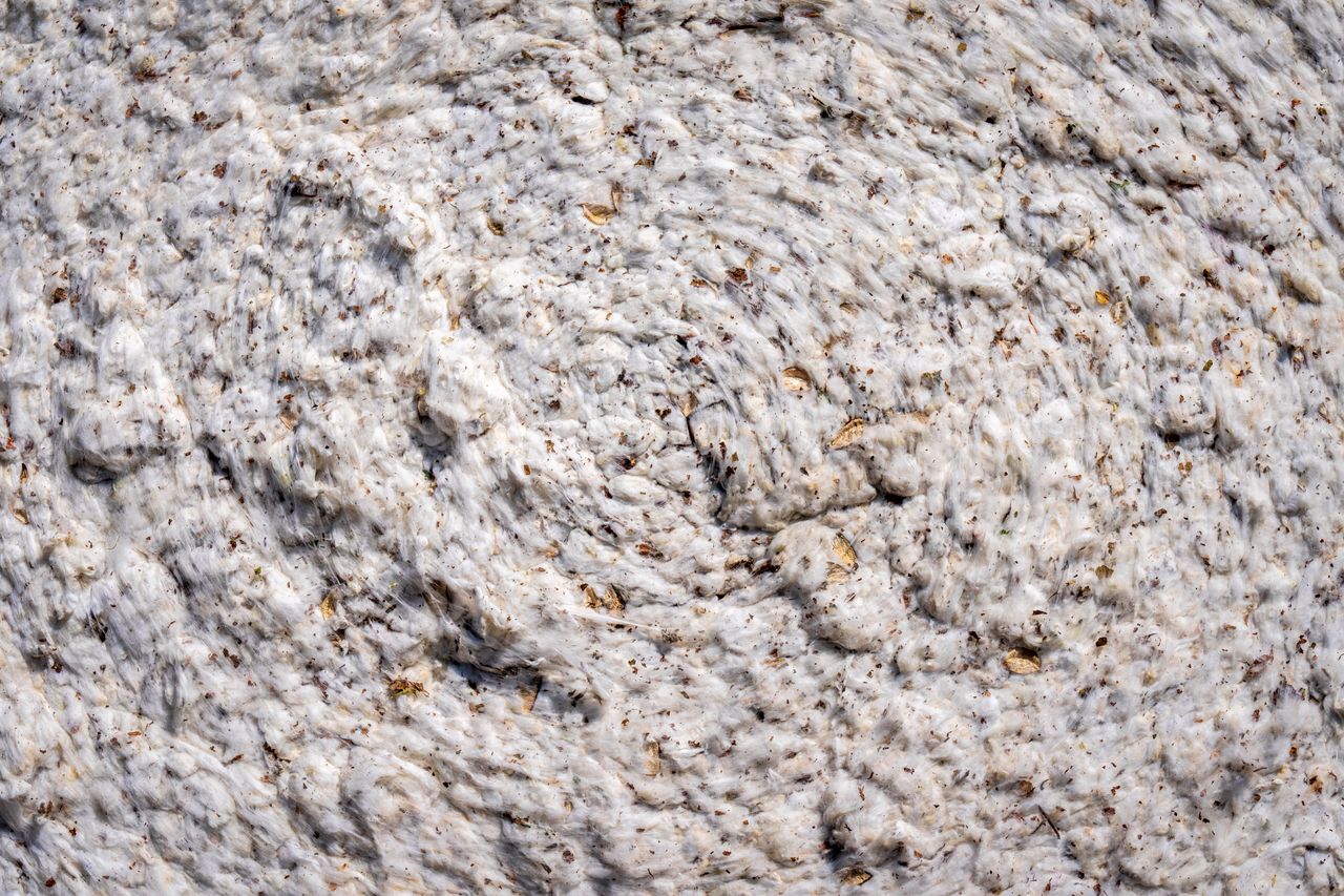 Close-up of a swirled fabric texture, showcasing cotton in an abstract pattern.